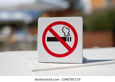 "No smoking" sign. Smoking is prohibited in public places. Forbidding banner on the table against the backdrop of a public place. Attention, do not smoke. - Shutterstock ID 2348781119