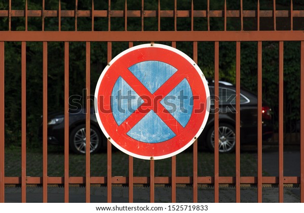 No Stopping\
Sign. Car parking behind no stop sign on the street. The car stands\
on the prohibition of\
stopping.