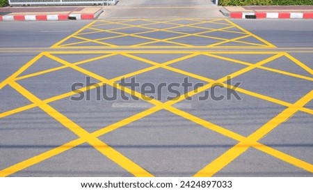 No stopping yellow crisscross zone traffic sign on asphalt road surface at the entrance and exit way of hospital.