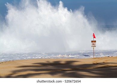 No Swimming Danger Sign On The Beach On The North Shore Of Oahu Hawaii With Palm Tree Shadow And Giant Wave Splash