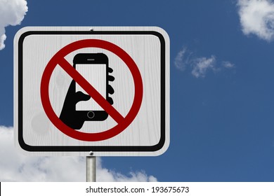 No Texting and Driving Sign, White Information sign with symbol of a hand and texting with blue sky background