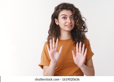 No Thank You. Portrait Uncomfortable Awkward Young Curly-haired Woman Raise Palms Rejection Apology Gesture Really Sorry Cannot Attend Party Declining Invitation, Standing White Background