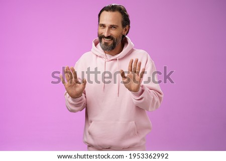 No thanks pass. Charming polite manly adult bearded man grey hair in pink hoodie apologizing refusal raise palms rejection gesture declining offer smiling say sorry not interested, purple background