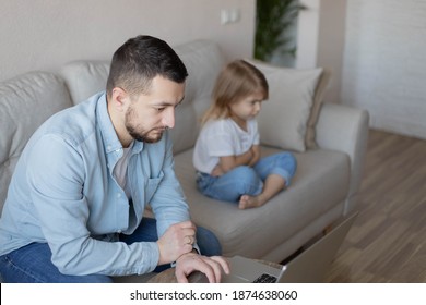 No Time For Child. Dad busy with laptop, working online at home, sad bored offended daughter sitting nearby, free space.Family a businessman father working at a computer and his child angry.