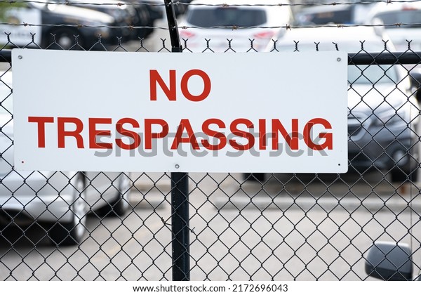 No trespassing sign\
hanging on fence