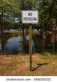 No trespassing sign outside of a fencing in lake - Shutterstock ID 1406535101