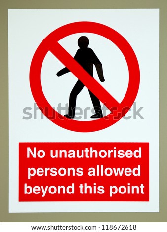 no unauthorised persons allowed beyond this point sign on a gray wall