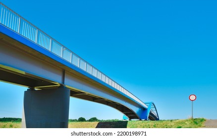 No Vehicles Traffic Road Sign And Bridge, Blue Railing, Clear Sky 