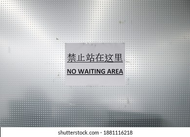 No Waiting Area Sign Written In English And Chinese On White Paper In A Wall