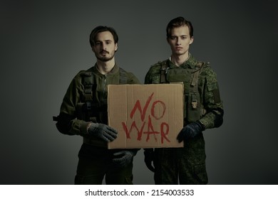 No War concept. Courageous soldiers in Protective Combat Uniform hold a sign 