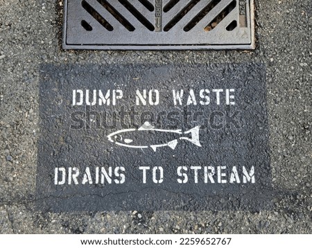 No waste dump sign on drain well on road