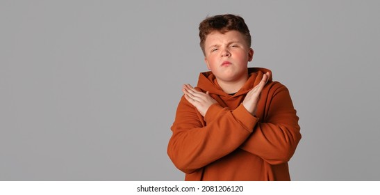 No Way, Absolutely Not. Stop. Serious Teenager Boy Showing Stop Sign By Crossed Hands And Looking At Camera, Standing Over Gray Background With Copy Free Space For Text