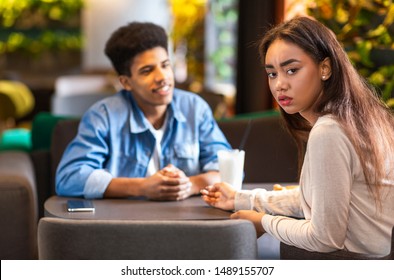 No Way Back. Frustrated Mixed Race Girl Looking At Camera, Ignoring Her Black Boyfriend, Cafe Interior