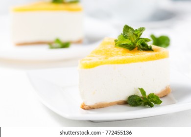 No-bake cheesecake decorated peach jelly and mint leaves on a white plate