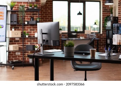 Nobody In Business Office With Computer And Instruments On Desk. Empty Startup Space Used To Work On Company Growth With Monitor And Equipment. No People In Workplace With Decorations.