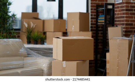 Nobody In Living Room Flat Full Of Cardboard Carton Boxes With Home Furniture And Things, Stacks Of Moving Cargo Storage. No People In Empty Apartment Space With Shipping Containers.