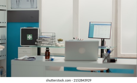 Nobody In Medical Office With Modern Technology And Tools Used For Health Care Service Consultation. No People In Empty Cabinet With Medical Equipment, Laptop And Checkup Instruments.