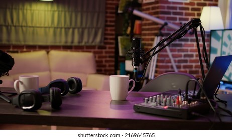 Nobody in podcast home studio with microphone boom arm and audio recording professional mixer on desk. Empty internet online radio setup for producing podcasts for social media. - Shutterstock ID 2169645765