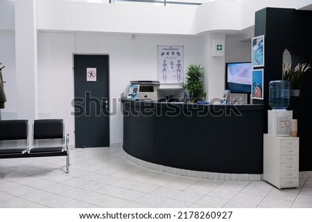 Nobody in waiting room with front desk reception and wall screen tv with promotional offer in private practice hopital. Waiting area for patients with doctor appointments in modern healthcare clinic.