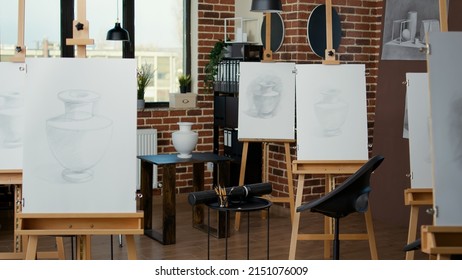 Nobody in workplace used for art class lesson with students to learn new drawing skills on canvas. Empty studio with artistic vase sketches on paper and wooden easel. No people in workshop