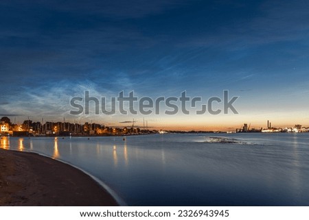 Noctilucent clouds over the Daugava river in Kipsala island, Riga, Latvia on July night.  Long exposure photography.