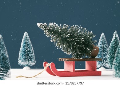 Noel Christmas Greeting Card With Place For Text. A Bright Christmas Tree Toy In The Form Of A Fir Tree On A Santa Claus Sleigh On A Dark Blue Background With Toy Christmas Trees. Snowing. Front View