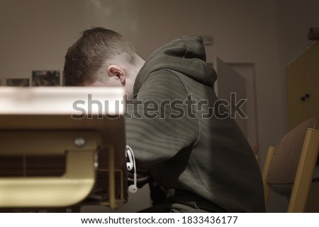 Noface boy sits in class and work