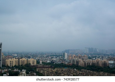 Noida Sky Scraper Under Construction In The Middle Of Smaller Buildings. Shot Against A Beautiful Cloudy Sky