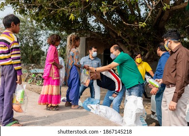 NOIDA, UTTAR PRADESH, INDIA - NOVEMBER 2020 : Group Of Young People Of NGO In India Distributing Food To Poor Children And Slum People During Pandemic. Giving Back To Society In Tough Time.