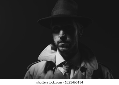 Noir film detective posing in the dark and staring at camera, thriller and crime concept - Powered by Shutterstock