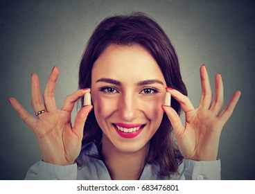 Noise Control. Woman Holding Ear Plugs Isolated On Gray Wall Background  