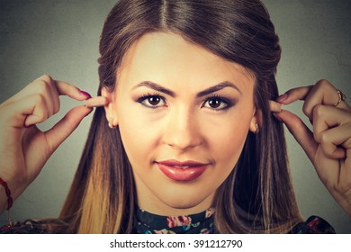 Noise Control. Young Woman With Ear Plugs Isolated On Gray Wall Background  