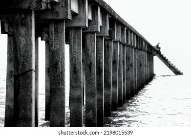 Noise. Grain. Black And White Tone. Row Of Concrete Pillars Along The Pier