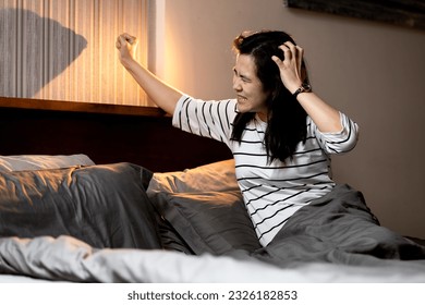 Noisy neighbor,loud voice of party,singing loudly,annoying loud unpleasant noise,upset woman sitting in bed hear very loud music wakes her up in the middle of night disturbing her sleep in bedroom