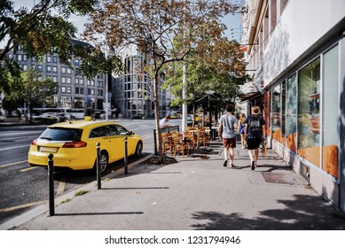 Noisy street, European city, sunny summer day, people rush to work, there is a taxi with driver on the side of street waiting for passenger. Yellow taxi service, fast car delivery to the place of call - Powered by Shutterstock