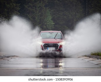 NOKIA, FINLAND - AUGUST 25, 2019: Audi Q5 35 TDI Quattro 2019 model year drives through a puddle on a road projecting huge splashes of water.