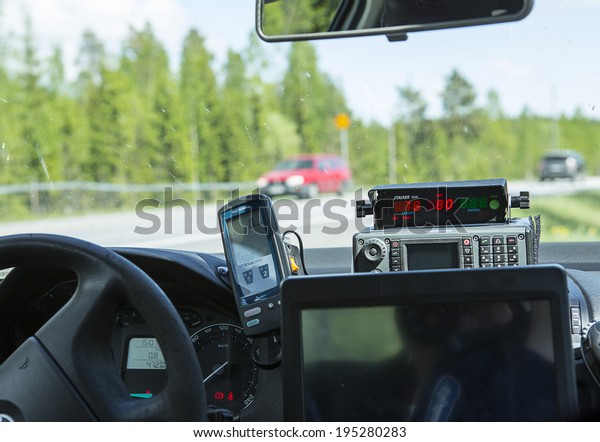 NOKIA, FINLAND - MAY 26.
Finnish police is doing traffic enforcement on the side of a road
on May 2014. Police is measuring speeding with stalker radar in
Skoda Octavia.