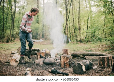 Nomad creating a campfire in spring forest.