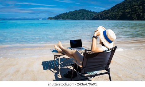 Nomad digital with laptop and running remotely with bright scenic view near poolside on the beach in summer time - Powered by Shutterstock