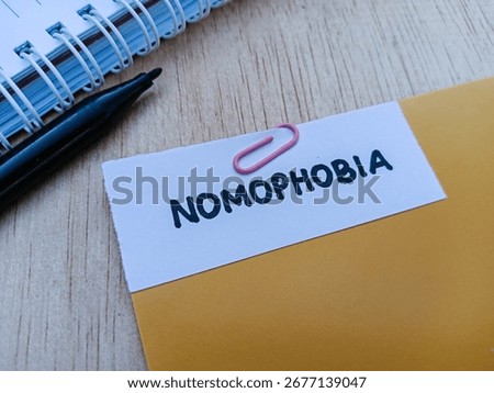 Nomophobia writting on table background.