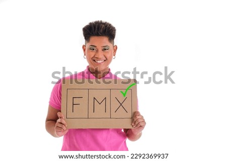 non binary asian person smiling in pink shirt holding gender non binary support sign on white background