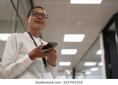 Non binary office worker standing in corridor - Powered by Shutterstock - Get 15% off with code: PIKWIZARD15