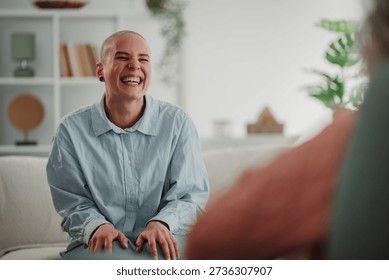 Non binary person finding happiness and support, laughing during a mental health therapy session in a bright, modern room