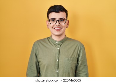 Non binary person standing over yellow background with a happy and cool smile on face. lucky person.  - Shutterstock ID 2234460805