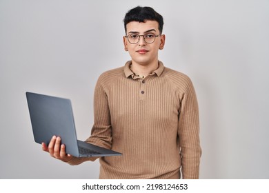 Non binary person using computer laptop relaxed with serious expression on face. simple and natural looking at the camera.  - Shutterstock ID 2198124653