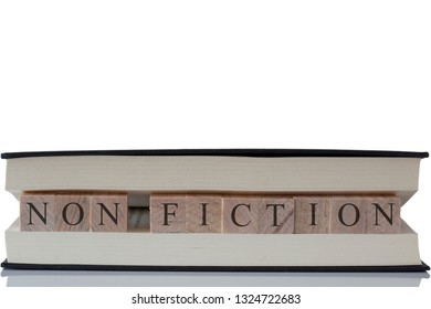 Non Fiction Written On Wooden Blocks Inside A Book Isolated On A White Background With Reflection