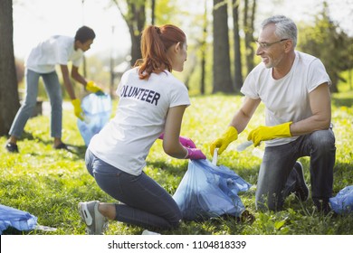 Non Profit Volunteer. Vigorous Two Volunteers Holding Garbage Bag And Chatting