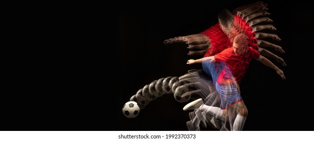 Non Stop Moving. Young Caucasian Football Soccer Player Playing With Ball In Motion In Mixed Light On Dark Background. Concept Of Healthy Lifestyle, Professional Sport, Action, Motion, Hobby, Team.