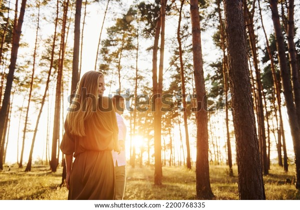 Non urban scene. Happy couple is outdoors in the\
forest at daytime.