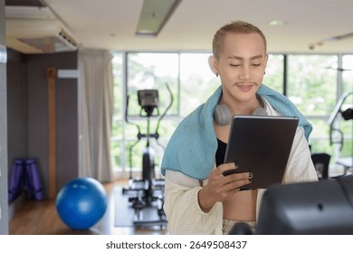 Non-binary Asian person exercising in gym wearing sportswear